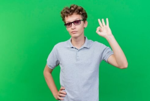 Парень в очках показывает что всё ОК